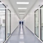 Couloir de salle blanche et laboratoire avec deux agents en combinaison stérile, illustration pour la formation ultra-propreté de DNDAgency.